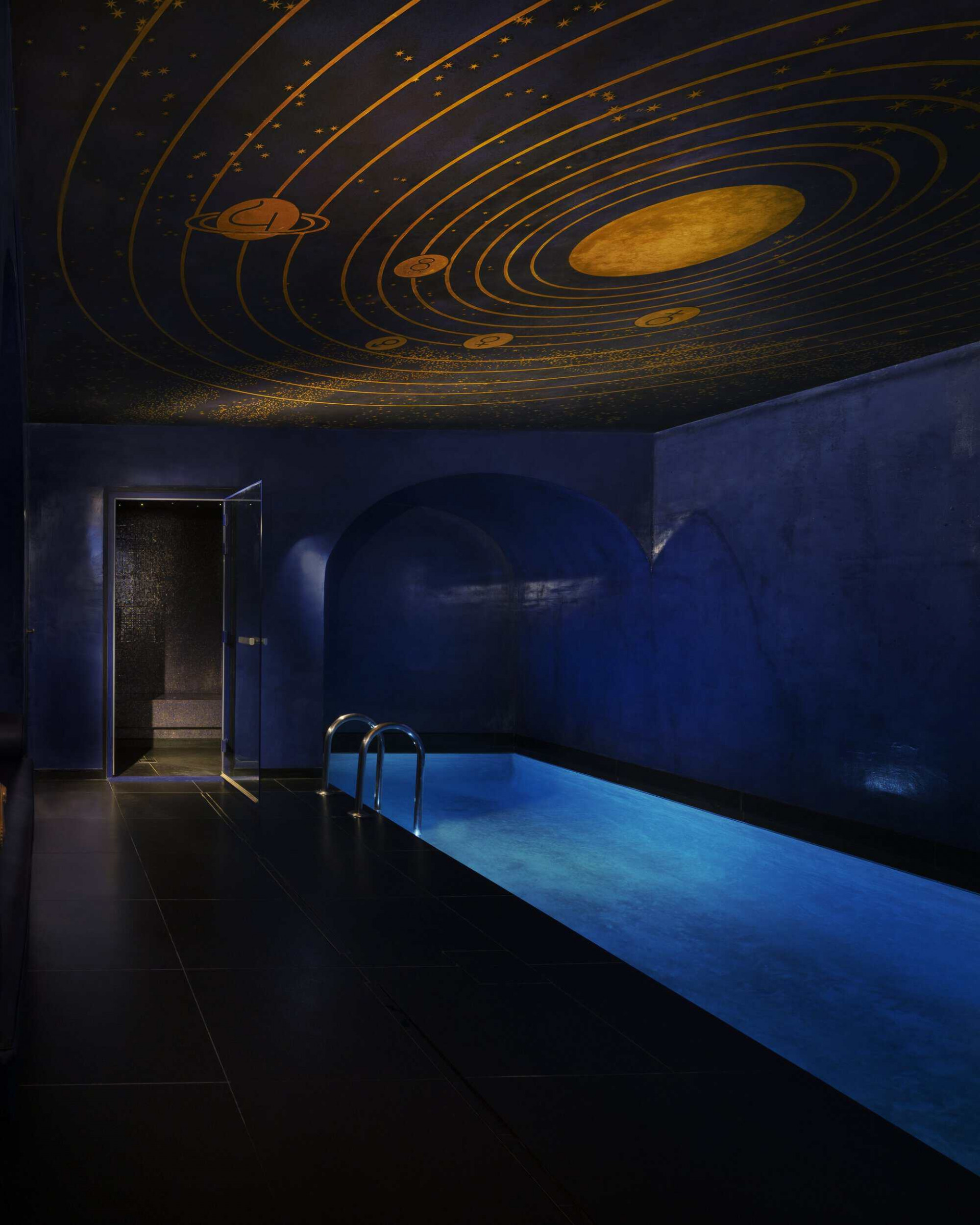 Spa room with a pool a golden galactic drawings on the cieling 